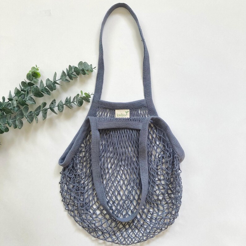 A gray cotton mesh reusable shopping bag with a long handles.