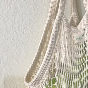 close up image of a cotton french market bag showing sides and straps