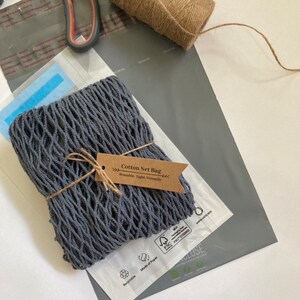 gray net bag folded and tied in a hemp with tag. image shows eco friendly packaging