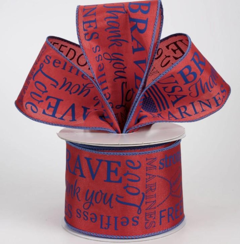 May include: Red ribbon spool with blue text that reads "Brave", "Thank you", "Love", and "Marines". The ribbon has a blue border and is arranged in a decorative bow.
