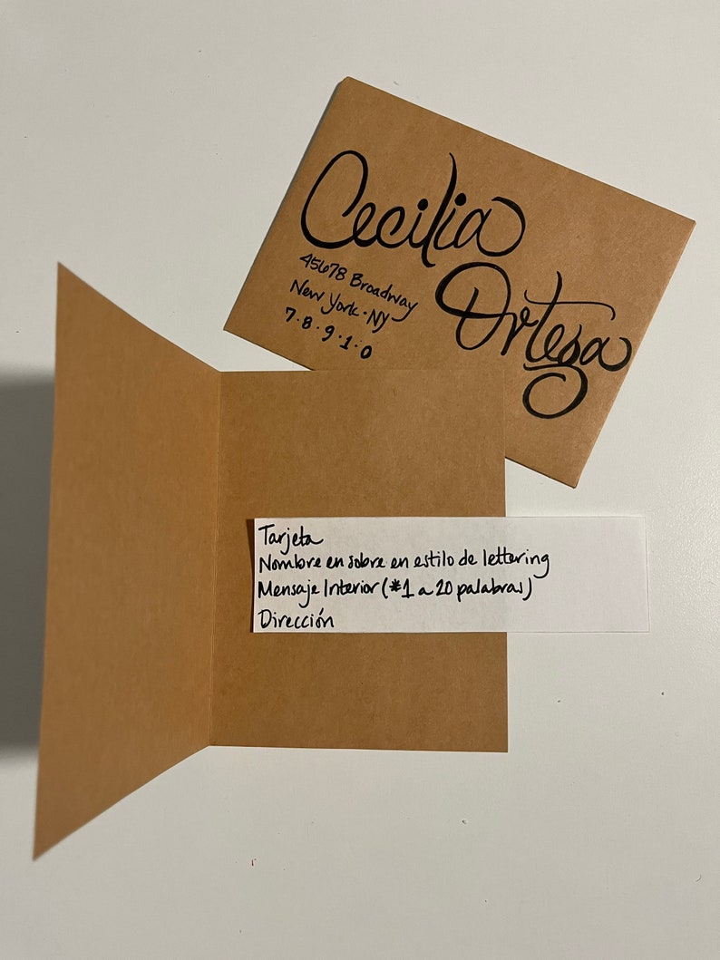 Pu&ograve; includere: Una busta marrone con un biglietto bianco all'interno. La busta ha il nome "Cecilia Ortega" scritto in corsivo sul davanti, insieme a un indirizzo e un numero di telefono. Il biglietto ha il testo "Tarjeta, Nombre en sobre en estilo de lettering, Mensaje Interior (#1 a 20 palabras), Direcci&oacute;n" scritto in inchiostro nero.
