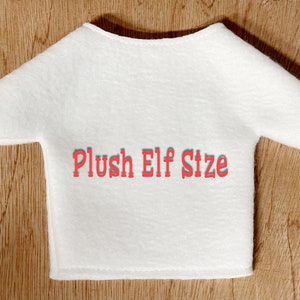 May include: White plush elf shirt with the text "Plush Elf Size" in red.