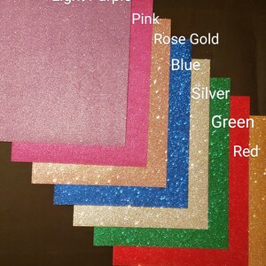 May include: A variety of glitter paper samples in different colors, including light purple, pink, rose gold, blue, silver, green, red, and gold.