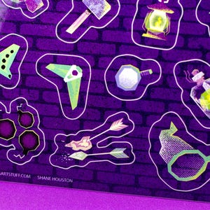 May include: A sticker sheet with fantasy-themed illustrations. The stickers include a hammer, lantern, potion bottle, arrows, and other tools, all outlined in white against a purple brick wall background. The artist's website is visible.