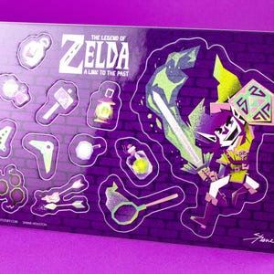May include: A sticker sheet featuring characters and items from "The Legend of Zelda: A Link to the Past." The stickers include a sword, shield, and game icons, set against a purple brick wall background.
