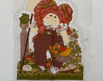 May include: A fabric panel with a Cabbage Patch Kid doll illustration. The doll has red hair, brown dungarees, and carries a shovel and a basket of vegetables. The panel includes instructions and the text "LEAVE OPEN FOR STUFFING".