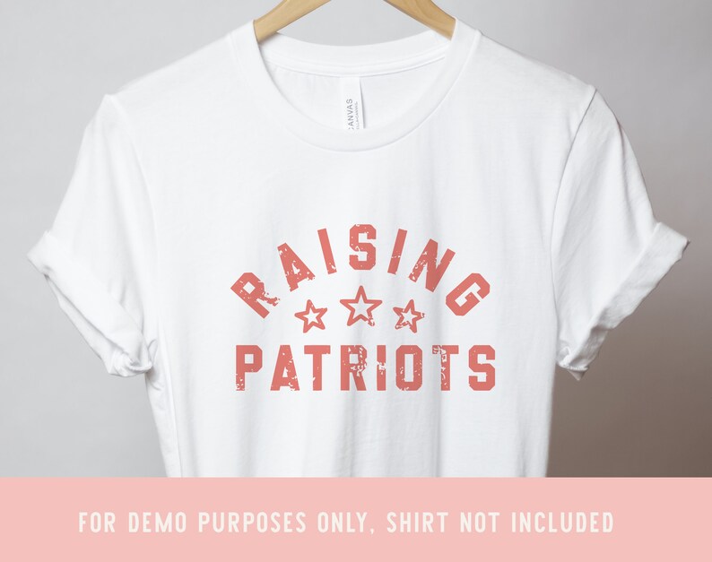 May include: White t-shirt with a red distressed graphic that says "Raising Patriots" with three stars.