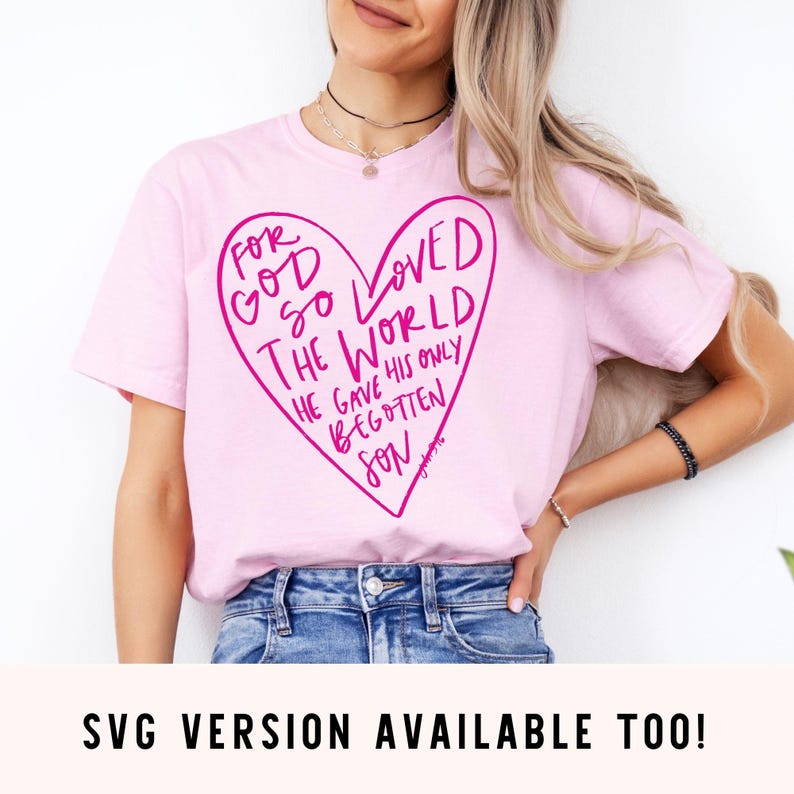 Puede incluir: Camiseta rosa con un gr&aacute;fico de coraz&oacute;n rosa que dice "Porque tanto am&oacute; Dios al mundo, que dio a su Hijo unig&eacute;nito."