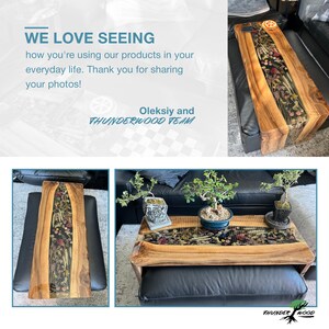 May include: Wooden coffee table with a live edge design. The table features a clear resin inlay filled with dried flowers and plants. The text "WE LOVE SEEING" and "THUNDERWOOD TEAM" is visible.