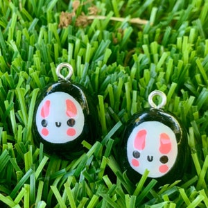 May include: Two black and white charms featuring a cute bunny face design. The bunny has pink ears and cheeks. The charms have a silver loop for hanging.