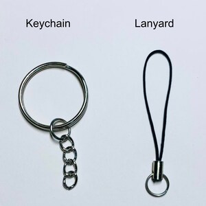 May include: A silver keychain with a metal ring and a chain. A black lanyard with a silver ring.