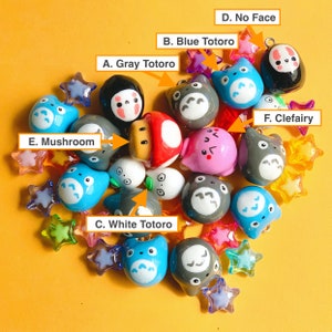 May include: A collection of colourful, handmade clay charms featuring characters from the Studio Ghibli film My Neighbour Totoro. The charms include Totoro, No Face, and other characters. The charms are perfect for adding a touch of whimsy to your jewellery or crafts.