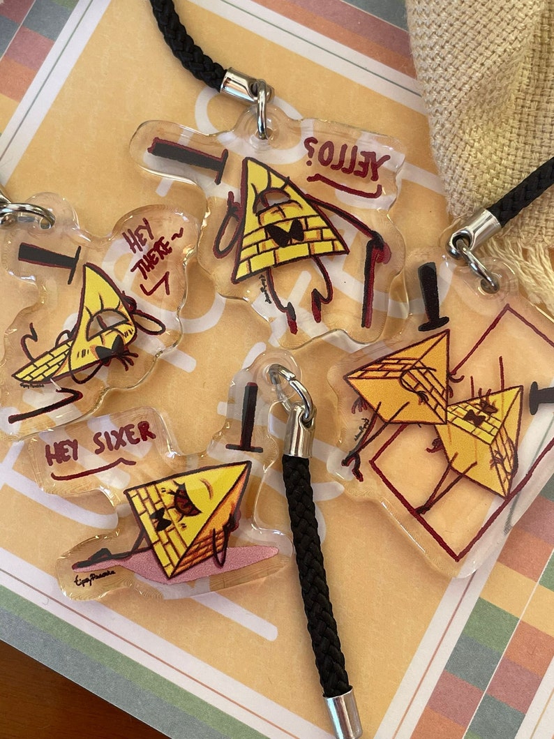 May include: Four yellow triangle-shaped keychains with black eyes and red outlines. The keychains feature different phrases, including "Hey There", "Hey Sixer", and "Yellow?"