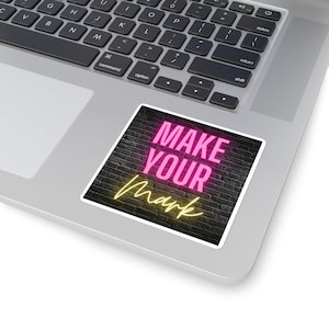 May include: A sticker with a black brick wall background and neon pink text that reads "MAKE YOUR mark" in a yellow neon outline.