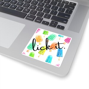 May include: A sticker with a white background and a pattern of colorful popsicles. The text "lick it." is written in black cursive font.