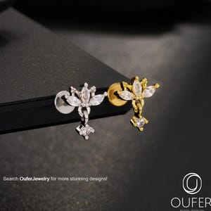 May include: Two stud earrings, one silver and one gold, each with a floral design and clear gemstones. The earrings have a dangling charm with a single gemstone. The image includes the text "Search OuferJewelry for more stunning designs!"