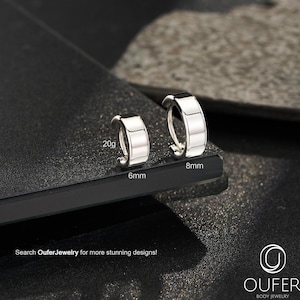 May include: Two silver hoop earrings displayed on a dark surface. One earring is labeled 6mm and 20g, the other is 8mm. The image includes the text "Search OuferJewelry for more stunning designs!"