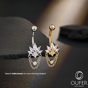 Puede incluir: Dos piercings para el ombligo, uno plateado y otro dorado, cada uno con un diseño floral y una cadena colgante. El anillo plateado tiene piedras preciosas transparentes, mientras que el anillo dorado tiene piedras preciosas transparentes y amarillas. El texto "Search OuferJewelry for more stunning designs!" es visible.