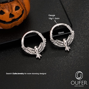 May include: Two silver body jewellery rings, each with a bird design. The rings are 10mm in diameter and have a gauge of 16g/1.2mm. The image includes the text "Search OuferJewelry for more stunning designs!"