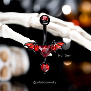 May include: Black and red belly button ring with a heart and bat wings design. The ring is 14 gauge and 10 mm long.  @ouferbodyjewelry