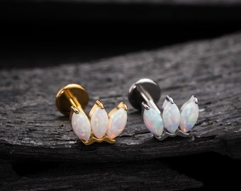 Puede incluir: Dos piezas de joyería corporal de flor de ópalo. Una es dorada y la otra plateada. Cada pieza tiene tres piedras de ópalo en forma de pétalos de flor.