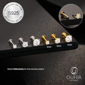 May include: A collection of silver and gold-toned stud earrings with clear, sparkling cubic zirconia stones. Sizes range from 2mm to 4mm. The image includes a close-up of a single earring and the text "STERLING SILVER S925". The brand name "OUFER BODY JEWELRY" is also visible.