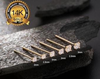 Könnte beinhalten: Sechs goldene Nasenringe mit klaren Zirkonia-Steinen. Die Steine sind in verschiedenen Größen von 2 mm bis 3 mm erhältlich. Die Ringe sind in einer Reihe vom kleinsten zum größten angeordnet.