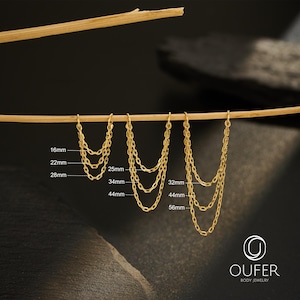 Puede incluir: Collares de cadena dorados de diferentes longitudes, colgados de una varilla de madera. Los collares se muestran con medidas en milímetros: 16 mm, 22 mm, 28 mm, 25 mm, 34 mm, 44 mm, 32 mm, 44 mm y 56 mm. La marca "OUFER BODY JEWELRY" es visible.