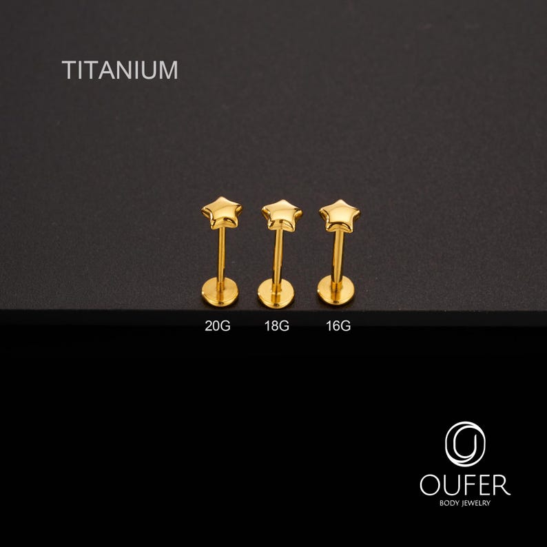 K&ouml;nnte beinhalten: Drei goldfarbene K&ouml;rperschmuck-Ohrstecker in Sternform. Die Ohrstecker sind mit 20G, 18G und 16G beschriftet. Das Wort "TITANIUM" steht &uuml;ber den Ohrsteckern. Das OUFER Body Jewelry-Logo befindet sich unten rechts.