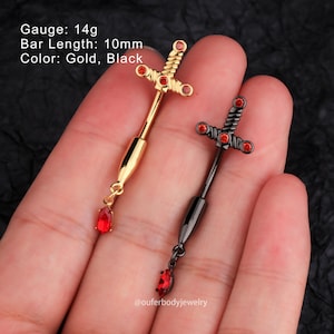 May include: Two surgical steel body jewelry pieces with a sword design and red gem accents. The sword design is set with clear rhinestones. One piece is gold and the other is black. Both pieces have a 10mm bar length and a 14 gauge.