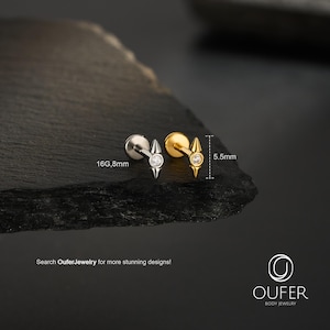 May include: Two stud earrings, one silver and one gold, each with a diamond-like center stone and a pointed, arrow-like design. The silver earring is labeled 16G, 8mm. The gold earring is 5.5mm in length. The text "Search OuferJewelry for more stunning designs!" is visible.