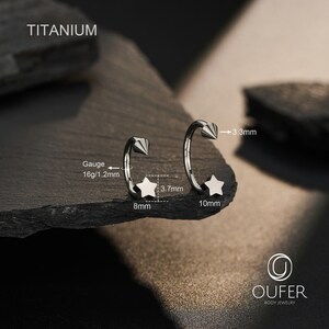 May include: Two titanium body jewelry pieces. Each piece has a star and a cone-shaped end. One star is 8mm, the other is 10mm. The gauge is 16g/1.2mm. The text "TITANIUM" is at the top. The brand logo "OUFER BODY JEWELRY" is at the bottom.