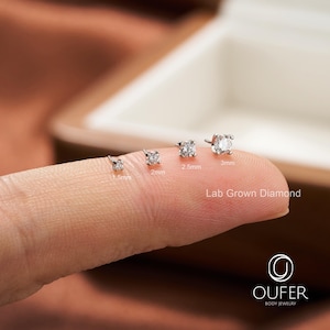 Puede incluir: Cuatro pendientes de diamantes cultivados en laboratorio de diferentes tama&ntilde;os (1,5 mm, 2 mm, 2,5 mm y 3 mm) se muestran en un dedo. Los diamantes est&aacute;n engastados en un metal plateado o blanco. El texto "Lab Grown Diamond" es visible.