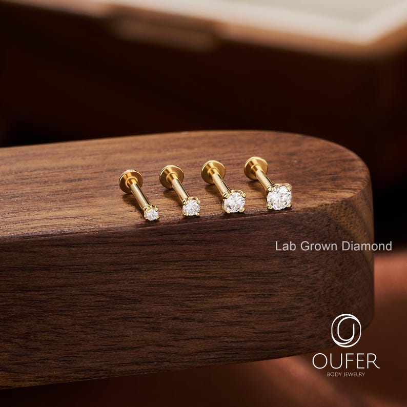 Puede incluir: Cuatro pendientes de bot&oacute;n de diamantes cultivados en laboratorio de color dorado, de diferentes tama&ntilde;os, se muestran sobre una superficie de madera. Los pendientes tienen un poste y una parte trasera plana. El texto "Lab Grown Diamond" es visible.