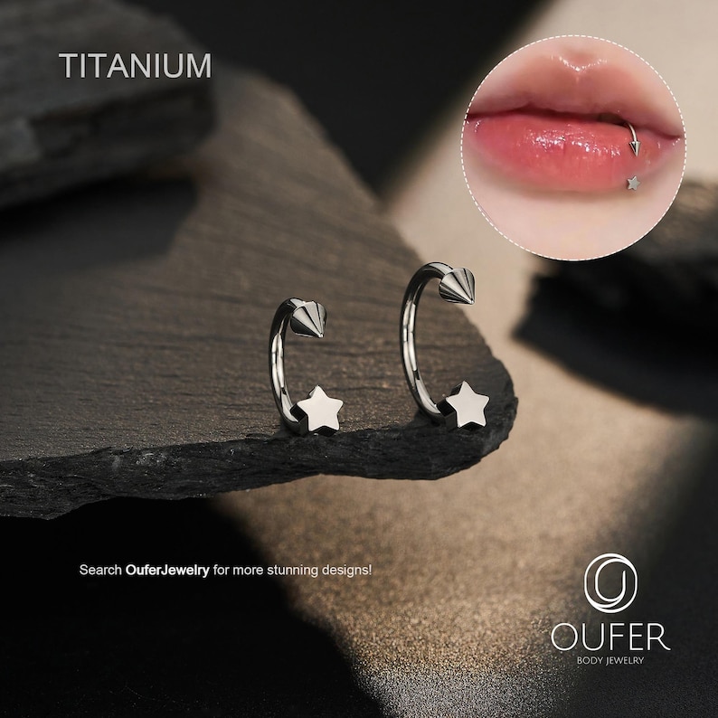 May include: Two silver-colored, curved body jewelry pieces with a star and cone design. The word "TITANIUM" is at the top left. The image also includes a close-up of a lip piercing with a star-shaped stud. The text "Search OuferJewelry for more stunning designs!" is at the bottom.