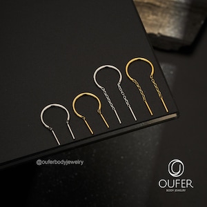 Pode incluir: Quatro brincos em forma de U dispostos em fila, com duas peças prateadas e duas douradas. Cada brinco consiste num arco liso ligado a dois segmentos de corrente pendentes que terminam em barras metálicas finas e retas.
