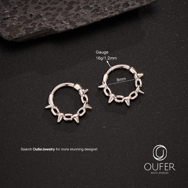 Op de afbeelding: Twee zilverkleurige oorringen met een ontwerp van een stekelketting. Elke oorring heeft een diameter van 8 mm en een dikte van 16g/1,2 mm. De tekst "Search OuferJewelry for more stunning designs!" is te zien.