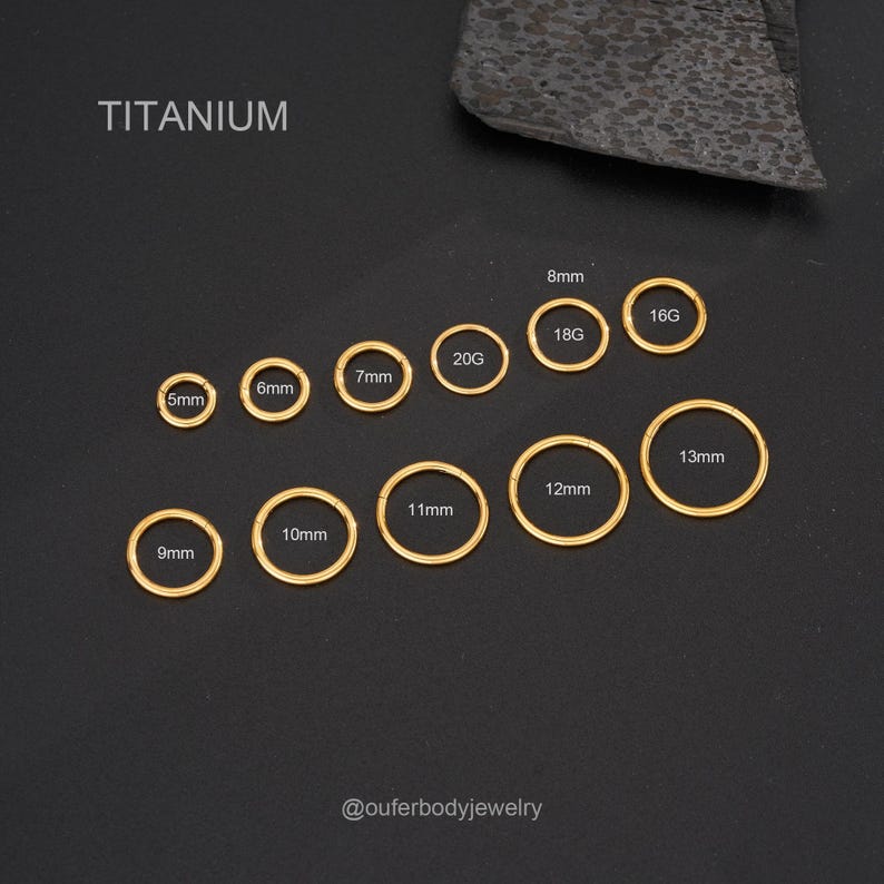 May include: A set of 10 titanium nose rings in various sizes, ranging from 5mm to 13mm. The rings are gold in color and are displayed on a black background. The sizes are labeled in millimeters.