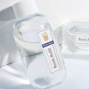 May include: A clear glass bottle with a white lid filled with a clear liquid. The bottle has a label that says "Sweetheart Reeds Refill" and "Proudly HandMade in Australia". The label also has a small gift box icon and the text "Fragrance Diffuser".