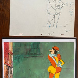 May include: Animation cel of a cartoon character in a colorful costume, set against a green and orange background. The character wears a red and yellow outfit with a ruffled collar and a pointed hat. The background includes a building.