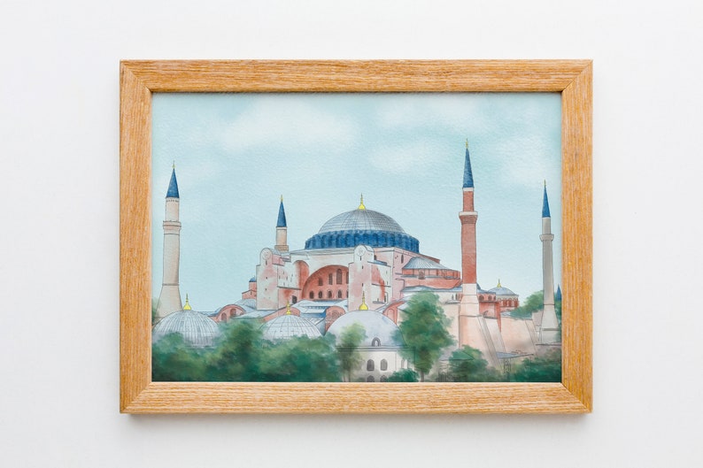 Puede incluir: Una pintura de acuarela enmarcada de la mezquita de Santa Sof&iacute;a en Estambul, Turqu&iacute;a. La mezquita se representa en un cielo azul claro con nubes blancas. La mezquita es de color rosa claro con una gran c&uacute;pula y seis minaretes.