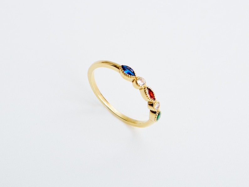 Peut inclure: Une bague en or avec cinq pierres pr&eacute;cieuses color&eacute;es serties en forme de marquise. Les pierres pr&eacute;cieuses sont bleues, blanches, rouges, blanches et vertes.