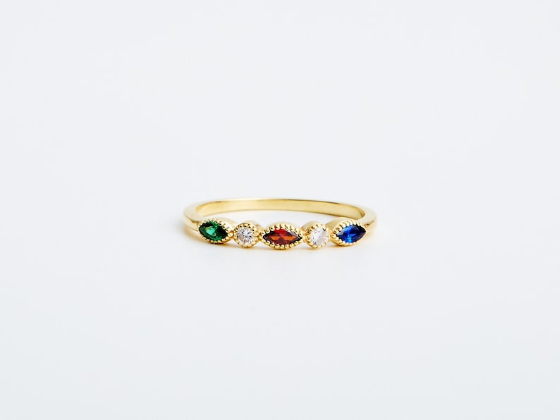 Peut inclure: Une bague en or avec cinq pierres en forme de marquise. Les pierres sont vertes, blanches, rouges, blanches et bleues.
