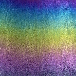 May include: A textured iridescent fabric with a gradient of colors, starting with a deep purple at the bottom, transitioning to a light green in the middle, and ending with a bright blue at the top.