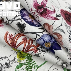 May include: White faux leather fabric with a floral print featuring pink, purple, red, and orange flowers. The fabric has a textured surface and the text "VOVO leather" is printed in the top left corner.