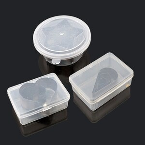 May include: Three clear plastic containers with lids. Each container holds a different shape: a star, a heart, and a teardrop.