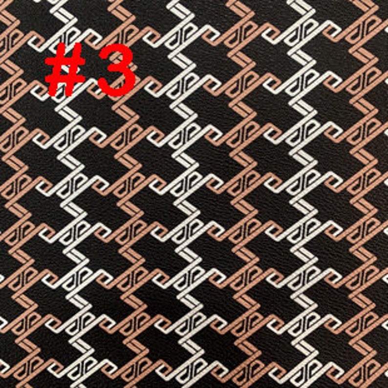 May include: Black fabric with a geometric pattern in white and light brown. The pattern is made up of interlocking squares and rectangles.