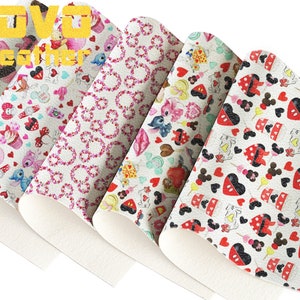 Può includere: Cinque fogli di pelle sintetica bianca con diversi motivi colorati. I motivi includono cuori, cupcake, teste di Topolino e altri personaggi Disney. Il testo "VOVO Leather" è stampato in giallo sul foglio superiore.