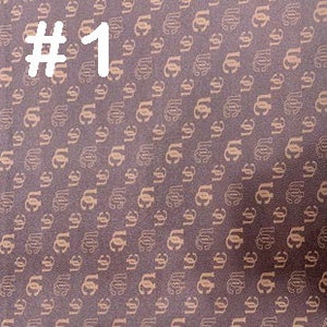 K&ouml;nnte beinhalten: Brauner Stoff mit einem sich wiederholenden Muster eines stilisierten Buchstabens "C" in einer helleren braunen Farbe.