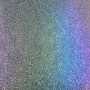May include: A close-up of a textured, iridescent surface with a rainbow gradient of colors, including purple, blue, green, and yellow.